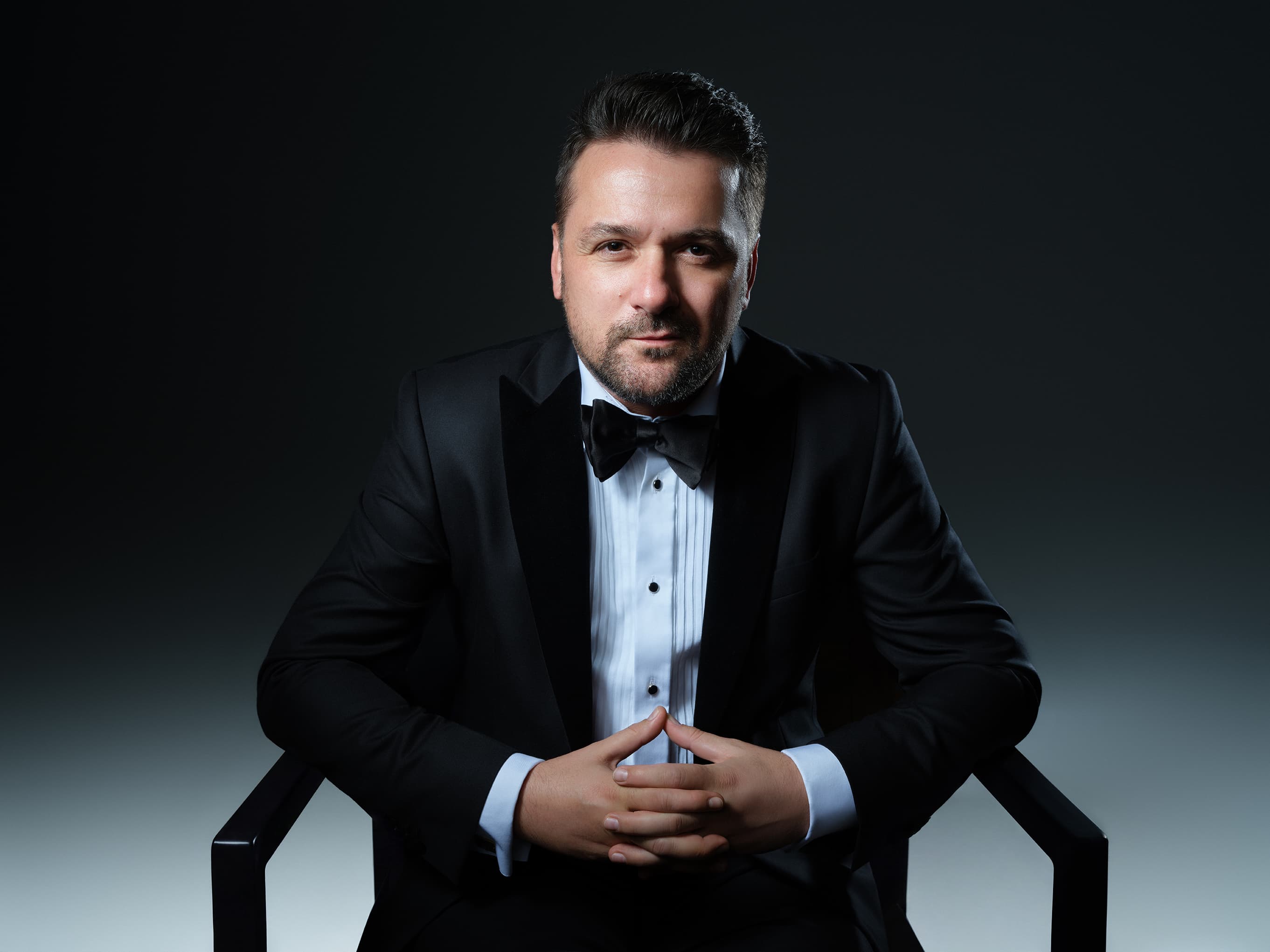 Radu Ionuț în ținută de gală, așezat, privind spre cameră
